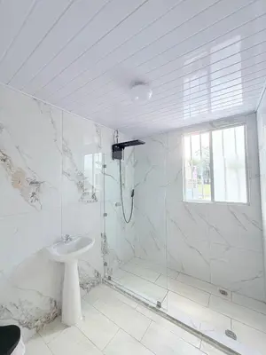 a white bathroom with a shower and a sink at Cabinas Diana in San José Pinilla
