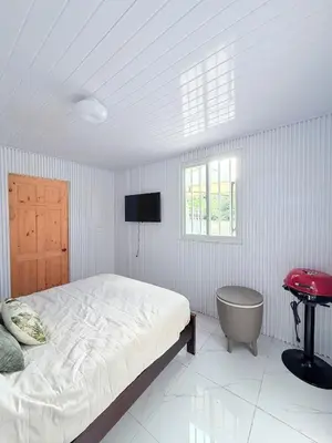 a bedroom with a bed and a table and a window at Cabinas Diana in San José Pinilla