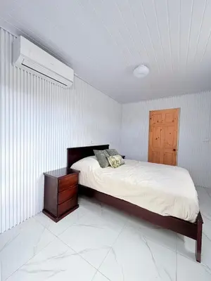 a bedroom with a large bed with a nightstand and a bed sidx sidx sidx at Cabinas Diana in San José Pinilla