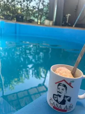 a cup of coffee sitting on a table next to a pool at Casa Abbi in Cuajiniquil