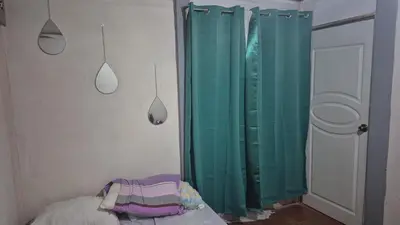 a bedroom with green shower curtains and a bed at Casa Abbi in Cuajiniquil