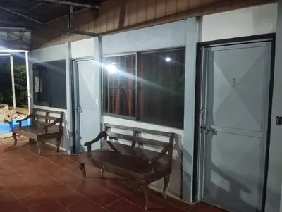 a porch with two benches and windows on a house at Casa Abbi in Cuajiniquil