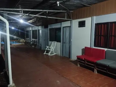 a room with a red couch and a chair at Casa Abbi in Cuajiniquil