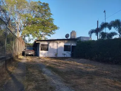 a small white house with a car parked next to it at Casa Abbi in Cuajiniquil