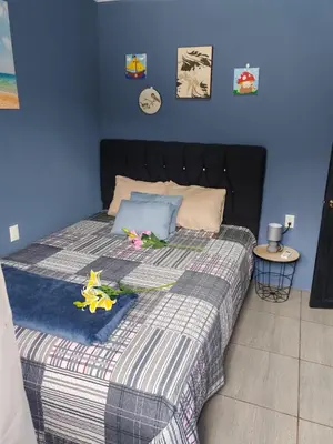 a blue bedroom with a bed with flowers on it at newly remodeled apartment , jaco herradura ,2 cuartos in Herradura