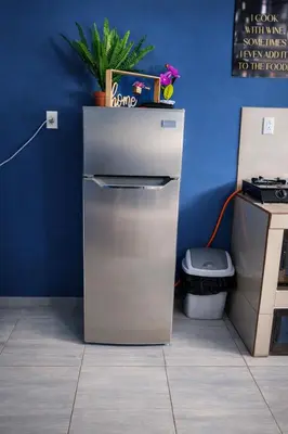 a refrigerator in a room with a blue wall at newly remodeled apartment , jaco herradura ,2 cuartos in Herradura