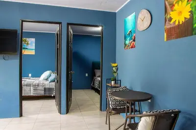 a blue room with a bed and a clock on the wall at newly remodeled apartment , jaco herradura ,2 cuartos in Herradura