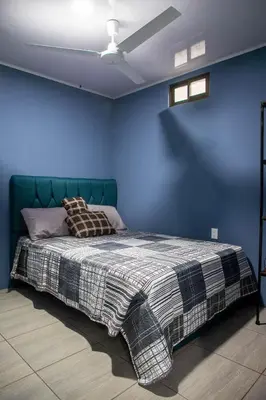 a bedroom with a bed with a blue wall at newly remodeled apartment , jaco herradura ,2 cuartos in Herradura