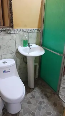 a bathroom with a white toilet and a sink at Hospedaje oye in Rivas