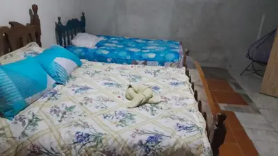 a bed with a teddy bear laying on it at Hospedaje oye in Rivas