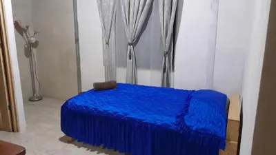 a blue bed in a room with a curtain at Hospedaje oye in Rivas