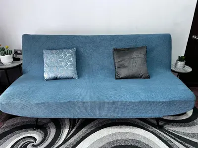 a blue couch with two pillows on a rug at Casa Girasol PZ in San Isidro