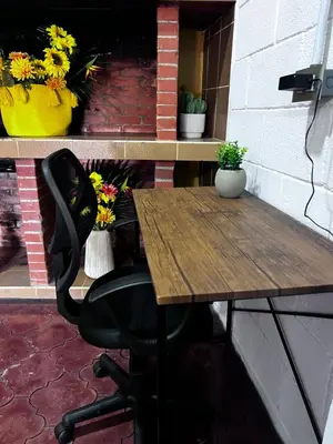 a wooden table with a black chair and flowers at Casa Girasol PZ in San Isidro