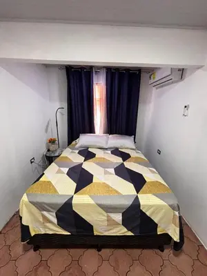a bedroom with a black and yellow quilt on a bed at Casa Girasol PZ in San Isidro