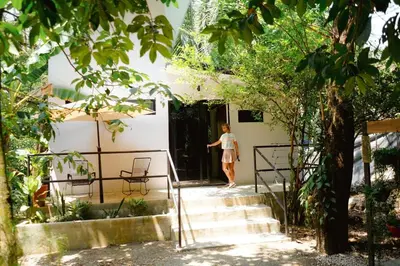 a woman walking up the stairs to a house at Ital Mountain modern hideaway with tropical vibes in Mal País