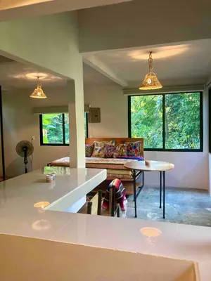 a kitchen and living room with a couch and a table at Ital Mountain modern hideaway with tropical vibes in Mal País