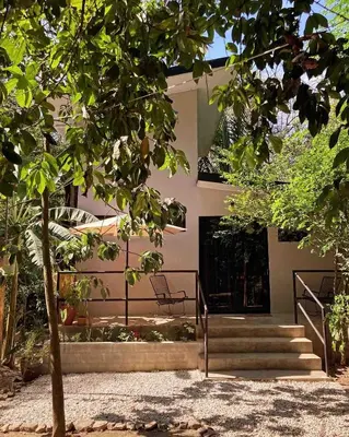 a building with stairs and a tree in front of it at Ital Mountain modern hideaway with tropical vibes in Mal País