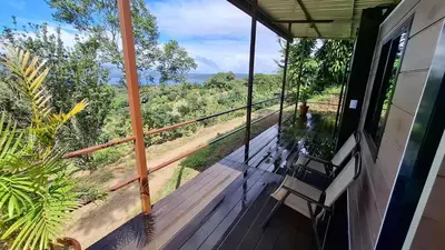 a porch with a bench and a view of the forest at Casa Loma del Lago - Lake Arenal View in Tilarán