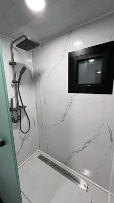 a bathroom with a tv on a white wall at Casa Loma del Lago - Lake Arenal View in Tilarán