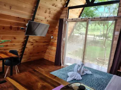 a room with a window and a tv in a cabin at Glamping Moku