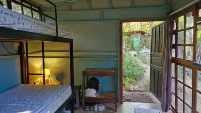 a bedroom with a bunk bed and a window at Hostal con camas compartidas - Pachamama Bio in Tamarindo