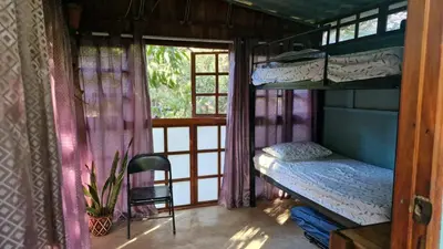 a room with a bunk bed and a window at Hostal con camas compartidas - Pachamama Bio in Tamarindo