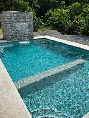 a swimming pool with a water fountain in a yard at Villa Solevila in Turrialba
