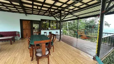 a room with a table and chairs on a deck at Villa Solevila in Turrialba
