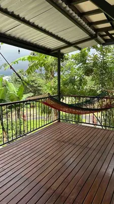a wooden deck with a railing on a balcony at Villa Solevila in Turrialba