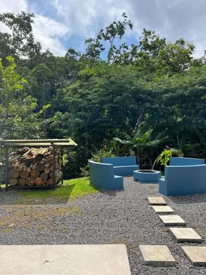 a garden with blue benches and a picnic table at Villa Solevila in Turrialba