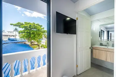 a room with a balcony with a view of a pool at Ozeano Hotel & Surf Bar in Jacó