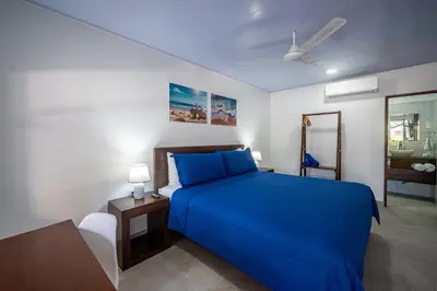 a bedroom with a blue bed and a night stand at Ozeano Hotel & Surf Bar in Jacó