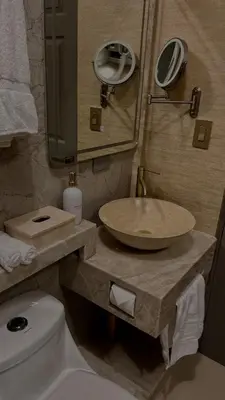 a bathroom with a sink and a toilet and a mirror at Arenal Stone House in Ángeles