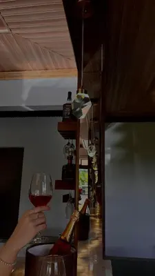 a person is holding a glass of wine at Arenal Stone House in Ángeles