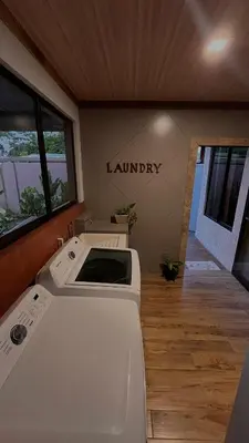 a laundry room with a sink and a sign that reads laundry at Arenal Stone House in Ángeles