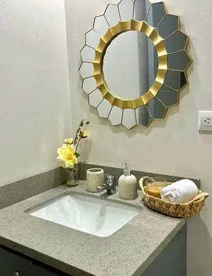 a bathroom sink with a large mirror above it at House equipped with a Jacuzzi in Quepos in Quepos