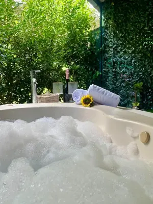 a bath tub filled with water with a sunflower in it at House equipped with a Jacuzzi in Quepos in Quepos