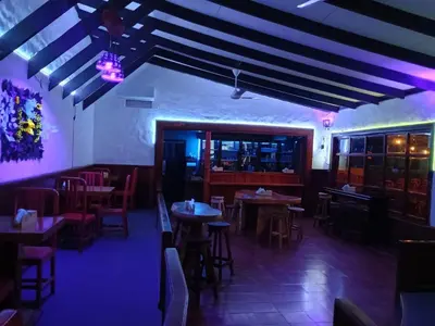 a restaurant with tables and chairs and purple lighting at Naranjo Easy Lodge in Paquera