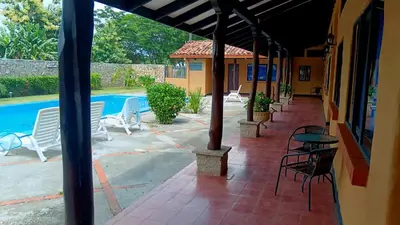 a patio with chairs and a table and a pool at Naranjo Easy Lodge in Paquera
