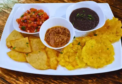 a plate of food with chips and salsa and dips at Naranjo Easy Lodge in Paquera
