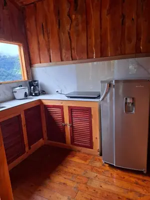 a kitchen with a stainless steel refrigerator and wooden cabinets at Cabaña Montaña Serena in El Copey