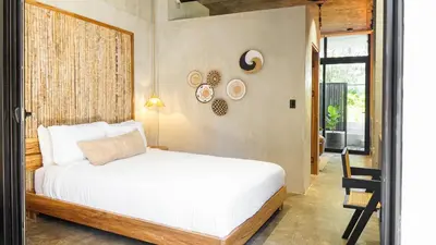 a bedroom with a white bed and a window at The Sandhaus Suite 1 in Jacó