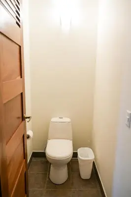 a small bathroom with a toilet and a door at Beachfront Bliss Steps to the beach in Playa Azul