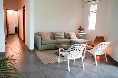 a living room with a couch and a table and chairs at Beachfront Bliss Steps to the beach in Playa Azul