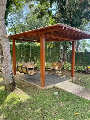 a park with two benches and a swing at Casa Duna in Herradura