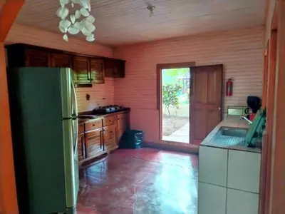 a kitchen with a green refrigerator and a window at Corozalito Turtle Lodge in Corozalito
