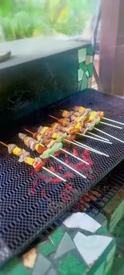 a bunch of skewers cooking on a grill at Corozalito Turtle Lodge in Corozalito