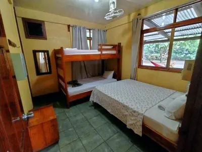 a bedroom with two bunk beds and a window at Corozalito Turtle Lodge in Corozalito