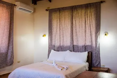 a bedroom with a bed with a animal on it at Manys house in Ballena