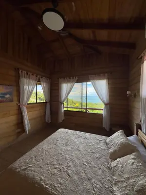 a bedroom with a bed and two windows at Manys house in Ballena